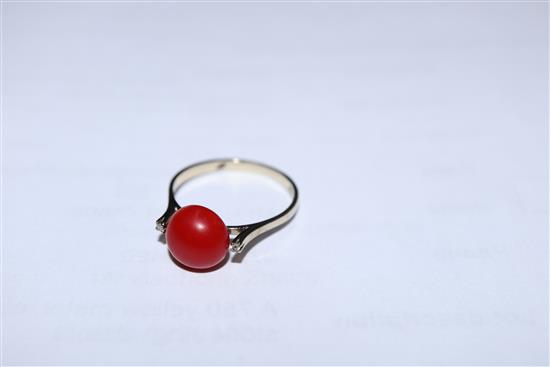 A 750 yellow metal, coral and diamond three stone ring, size O.